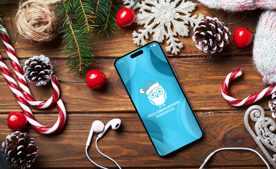 Gemeinde24 App auf einem Smartphone, dass auf einem weihnachtlich gedecktem Tisch liegt.